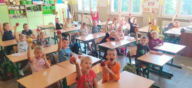 Uczniowie klasy 1a z jabłkami w dłoni.
