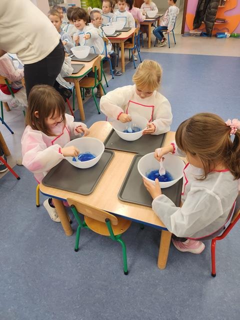 dzieci przy stolikach z miseczkami