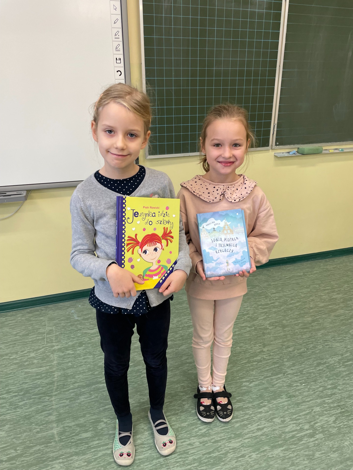 dziewczynki trzymają książki, które wygrały w konkursie
