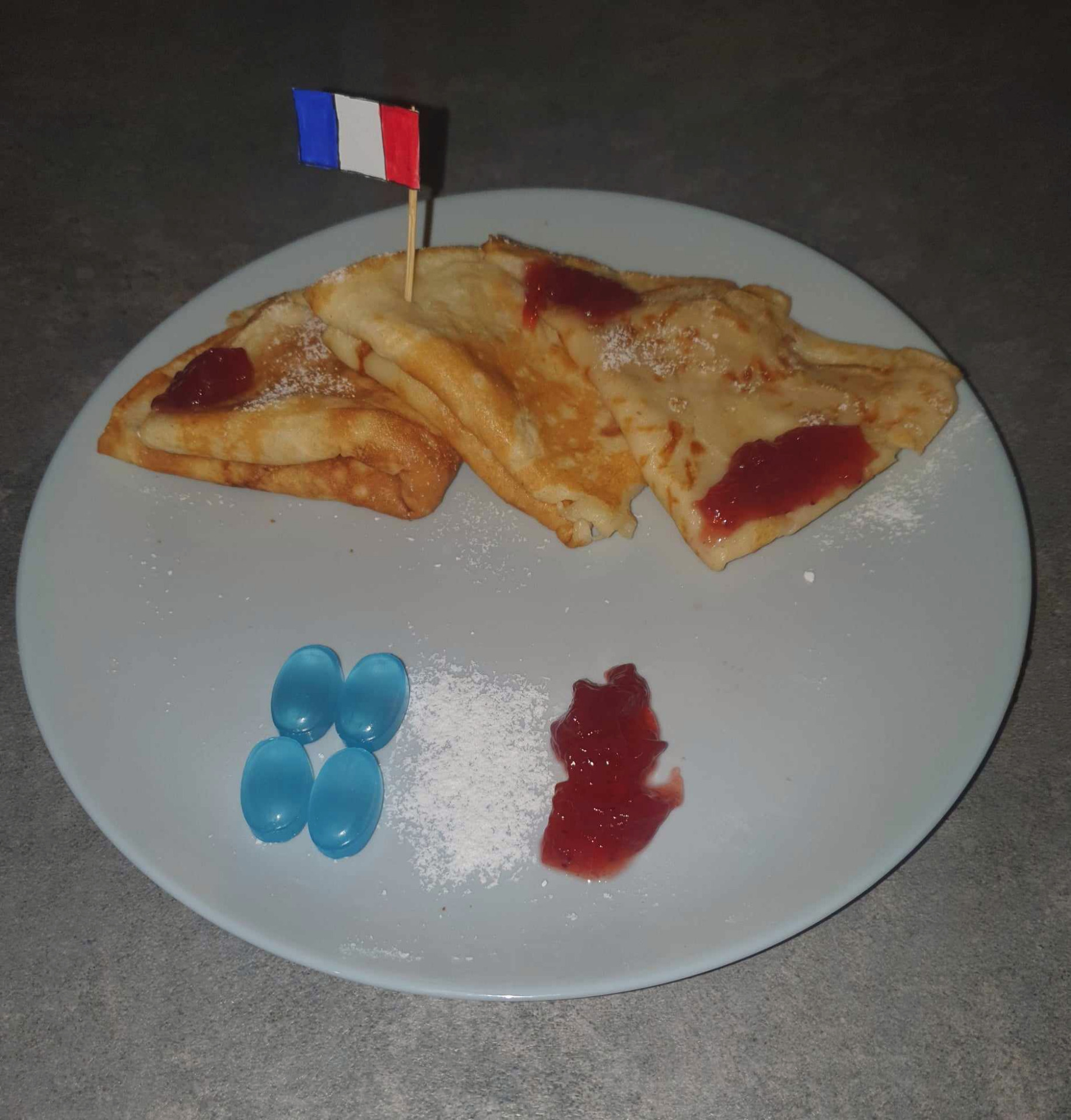 Zdjęcie przedstawia naleśniki oraz flagę Francji