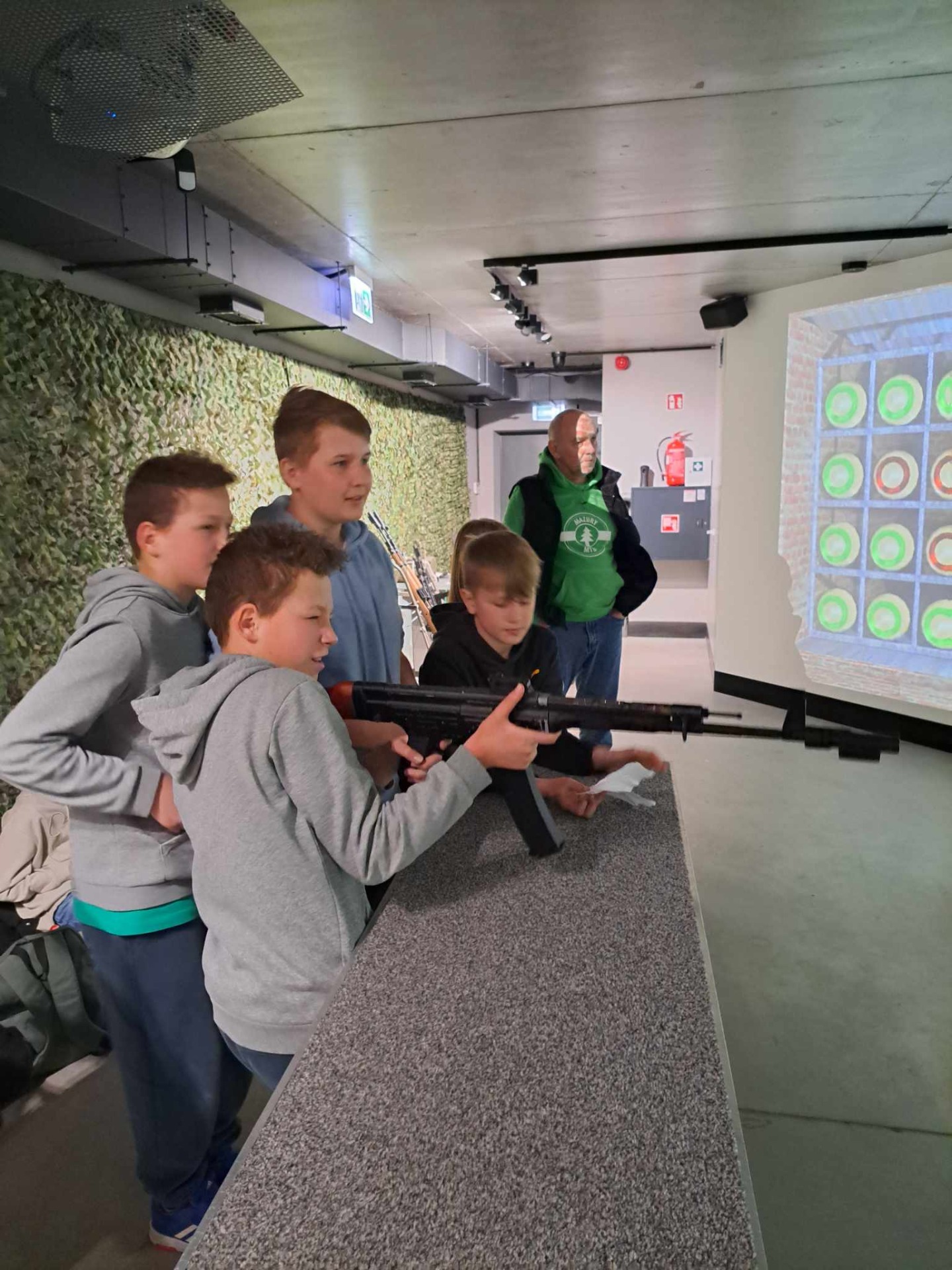 Grupa uczniów w wirtualnej strzelnicy.
