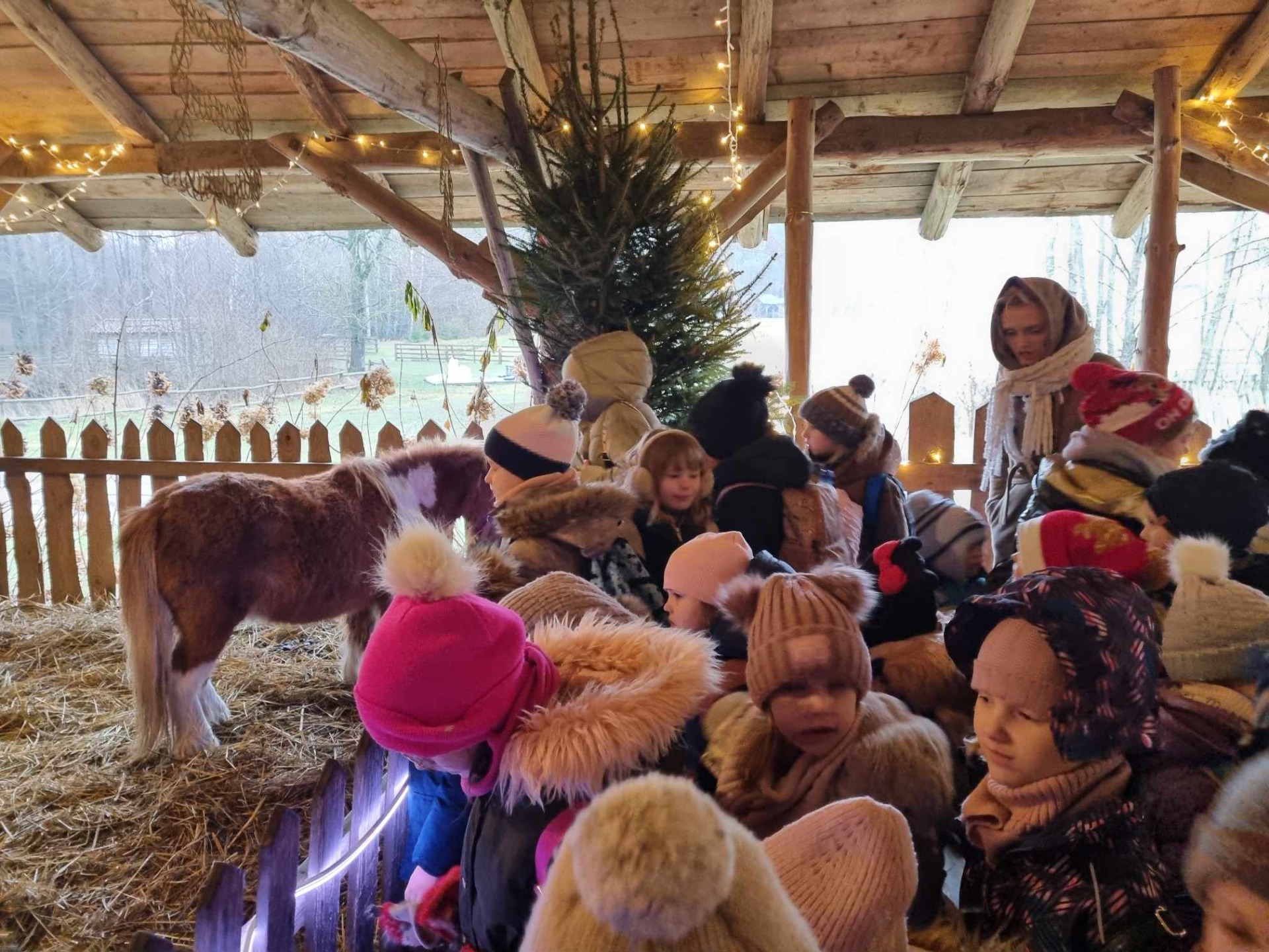 Grupa dzieci w szopce u   Świętego Mikołaja