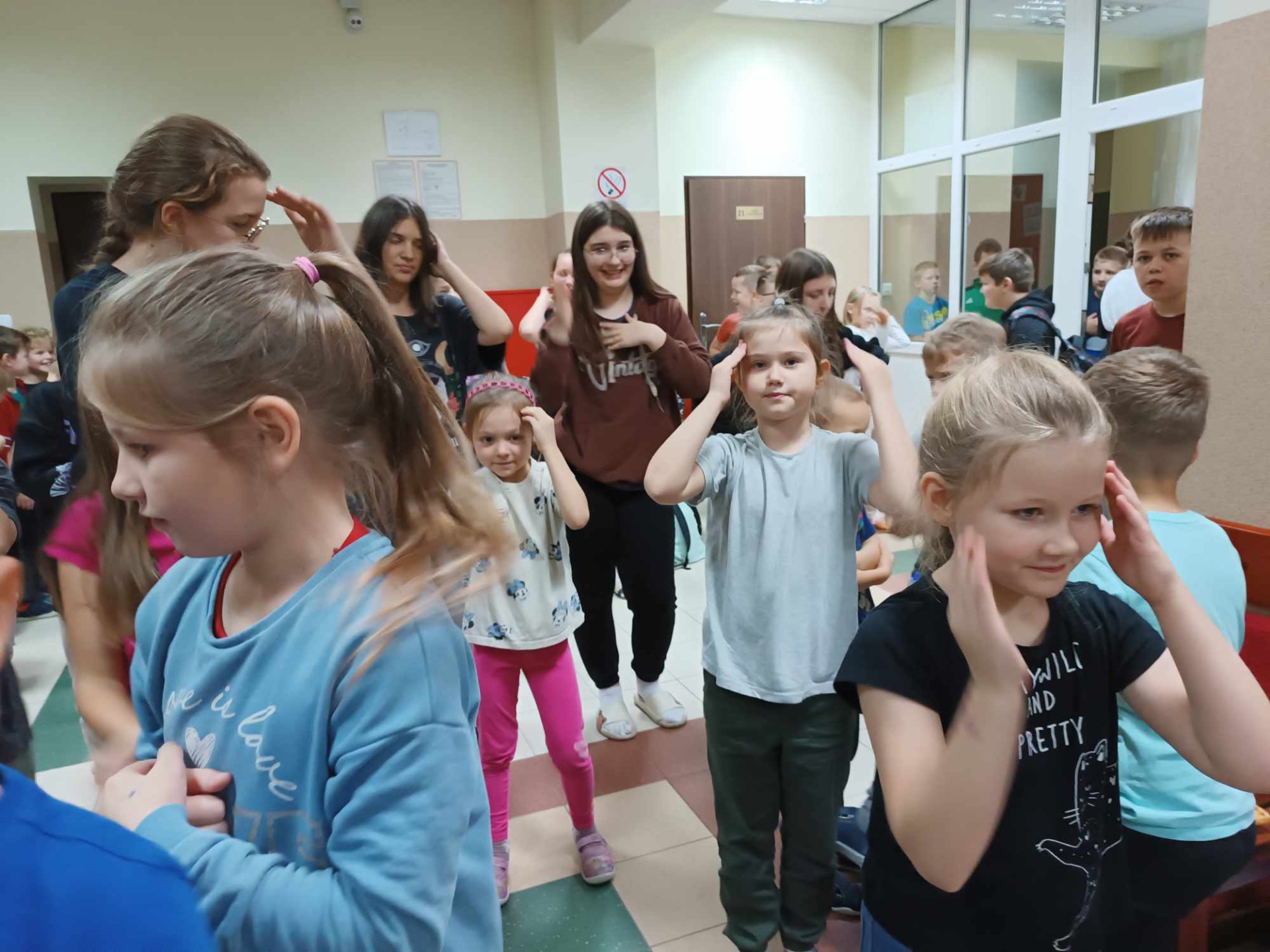 Uczniowie tańczą na szkolnym korytarzu