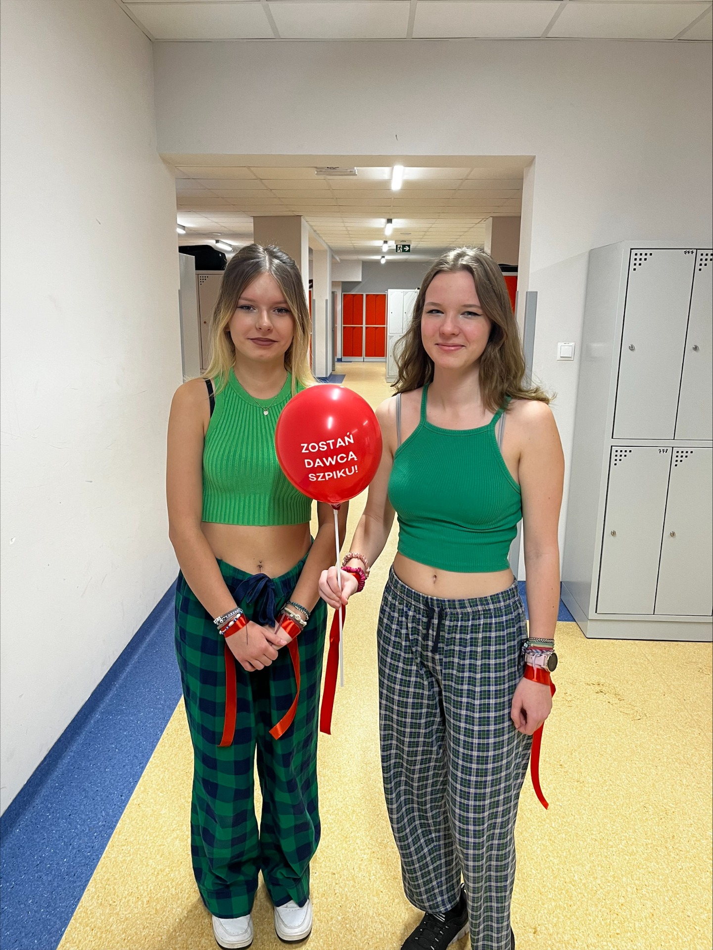 Dwie uczennice z czerwonym balonem z napisem "Zostań dawcą szpiku"